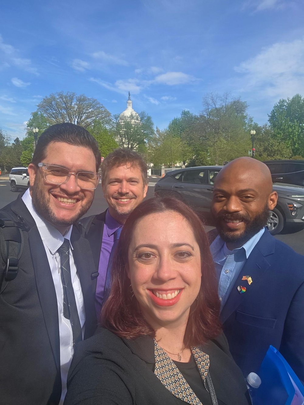 Four AAACT advocates smiling in front of the U.S. Capitol